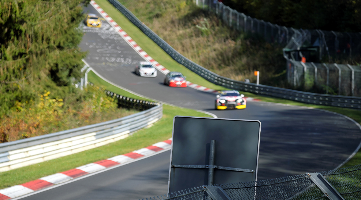 Racing cars approaching the corner on the Nürburgring track